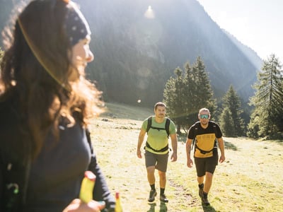 Wanderer vor dem Tal-Panorama auf einer grünen Wiese
